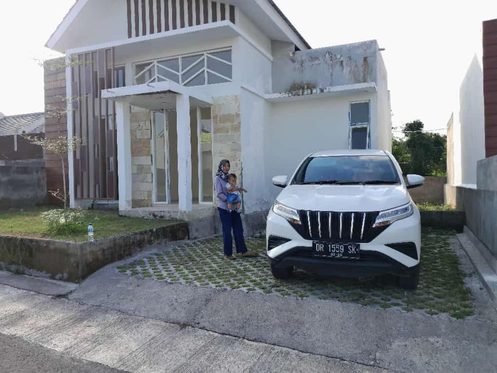 普拉亚Muja house villa的站在一辆白色汽车前面的女人