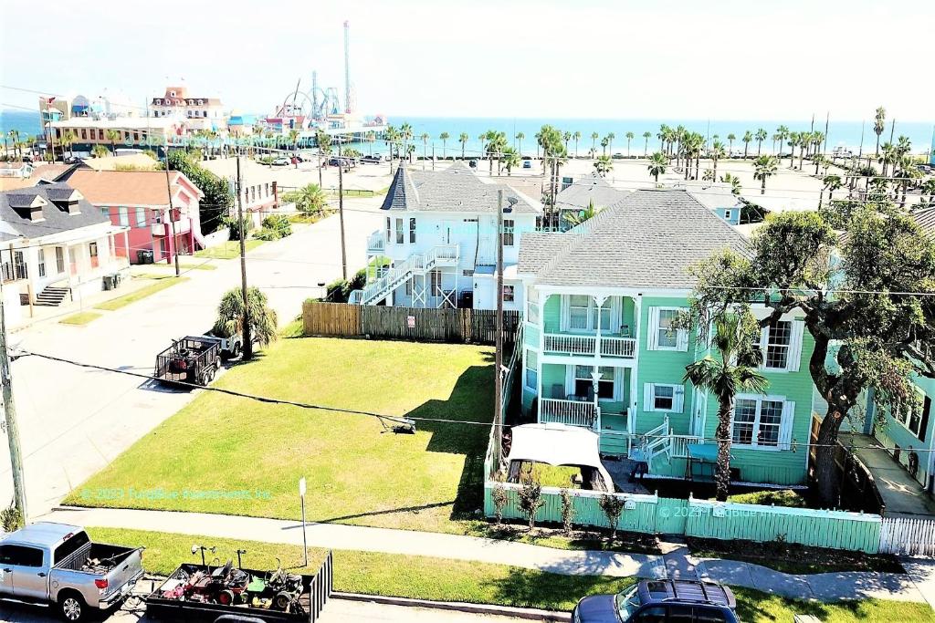 加尔维斯敦CasaAzul-2605A-Couples Retreat By Pleasure Pier, Beach, Seawall,a block away 5 Minutes from Strands and Cruise Terminal的街道上房屋和卡车的空中景观