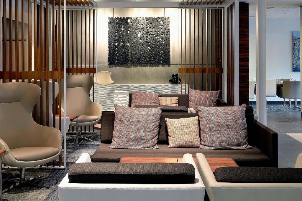 马赛AC Hotel by Marriott Marseille Prado Vélodrome的一间提供枕头、沙发和椅子的等候室