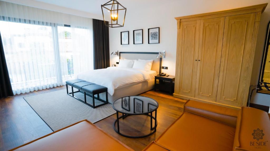 萨姆松Be Side Hotel的一间卧室配有一张床、一把椅子和一张桌子