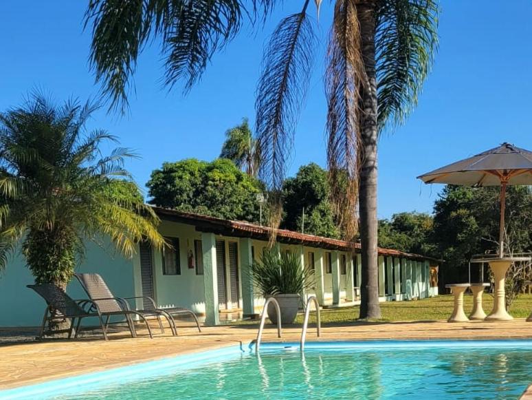 索科罗Pousada Rancho Caipira的一座带游泳池和棕榈树的房子