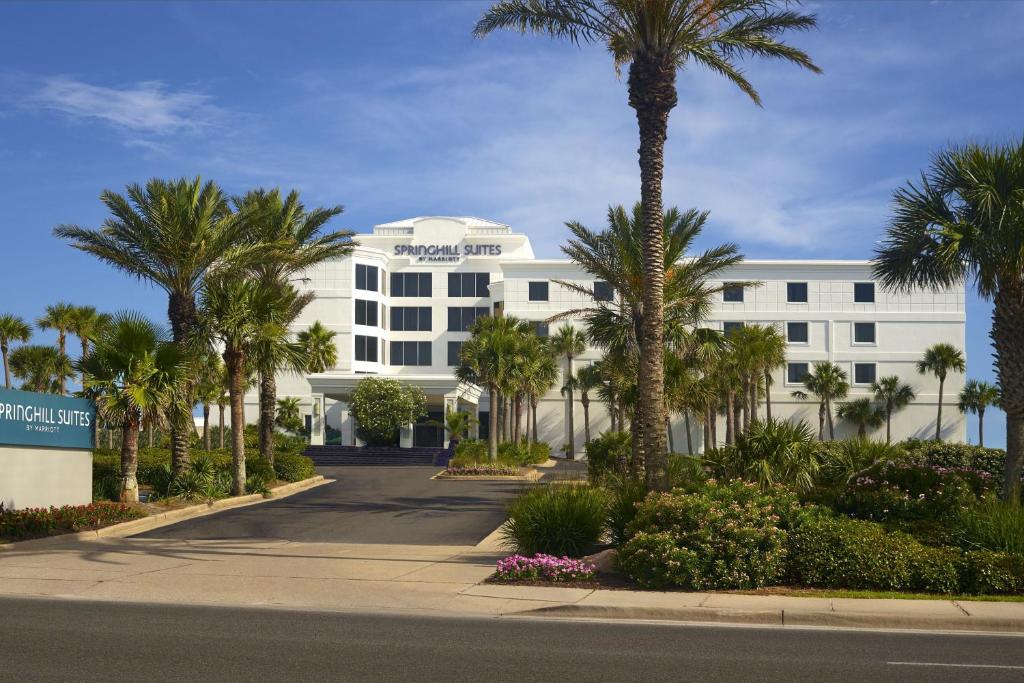 彭萨科拉海滩万豪彭萨科拉海滩春季山丘套房酒店的一座白色的建筑,种植了棕榈树,街道上