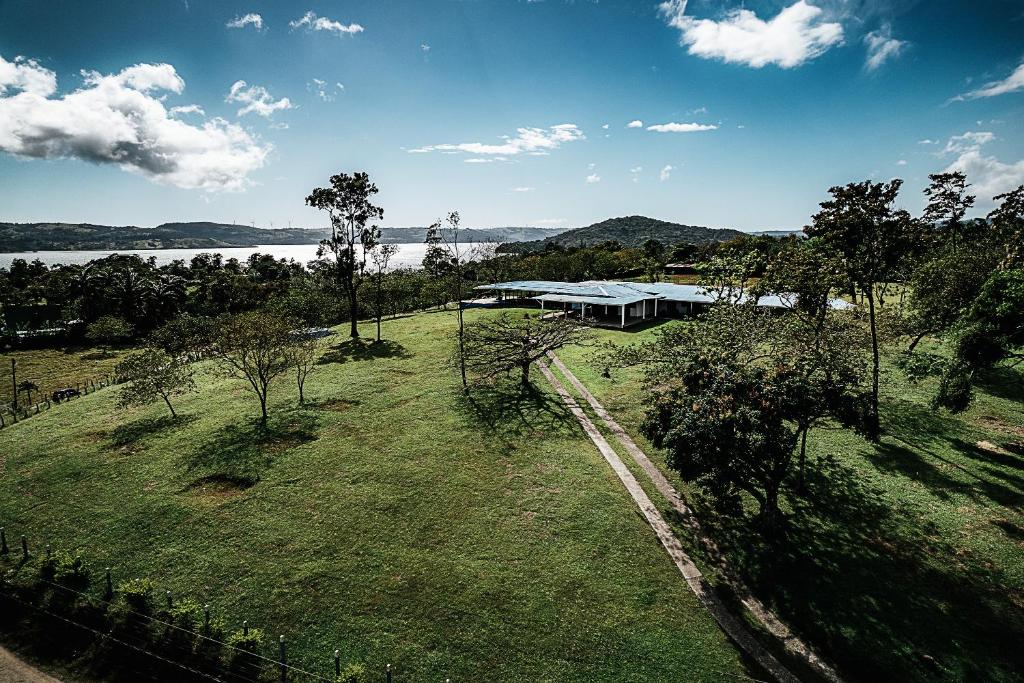 纽沃阿雷纳尔Hotel Little Paradise的享有一座建筑的空中景色,位于一个有湖泊的田野上