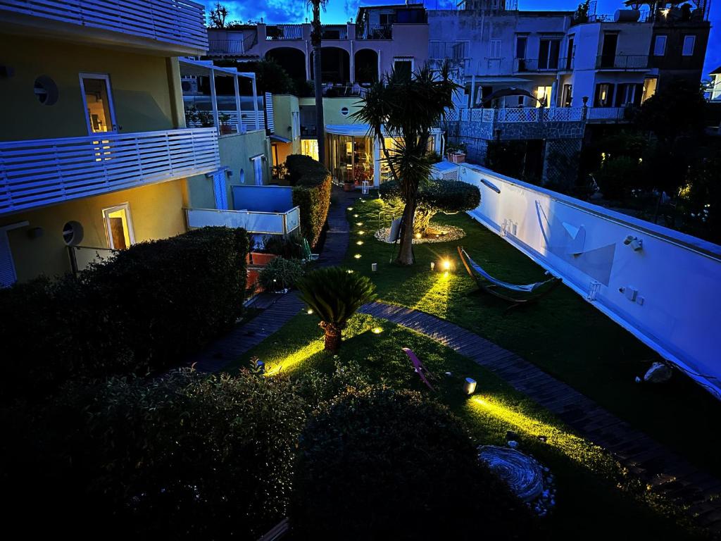 伊斯基亚玛莉娜10精品设计酒店的花园,种植了棕榈树,晚上有灯光