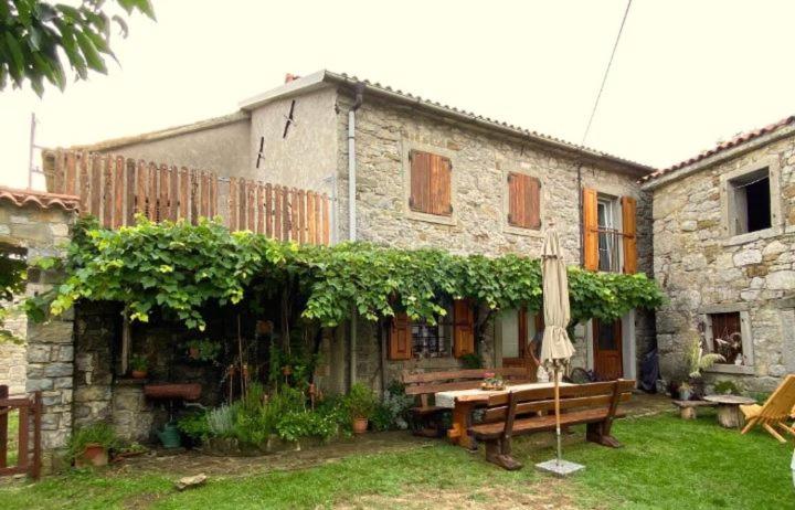 Pri kovačih, Istra autentica的石头房子,带长凳和遮阳伞