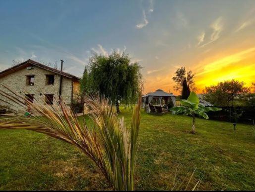 奥维多Sagasta Rural - Oviedo的地里的房子,背景是日落