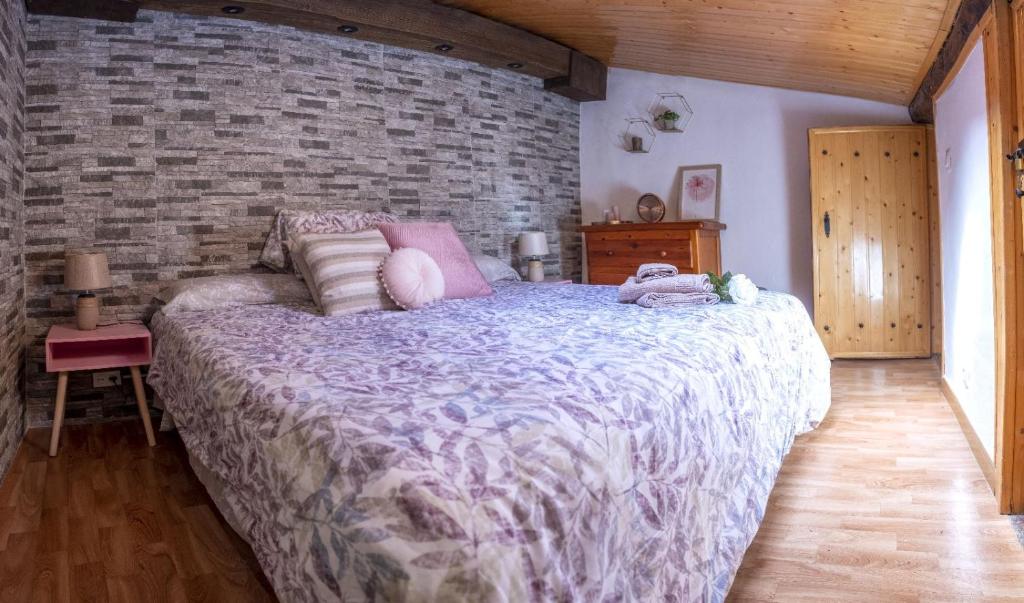 佩德罗－贝尔纳多Casa Rural El Burrito de Gredos的一间卧室设有一张大床和砖墙