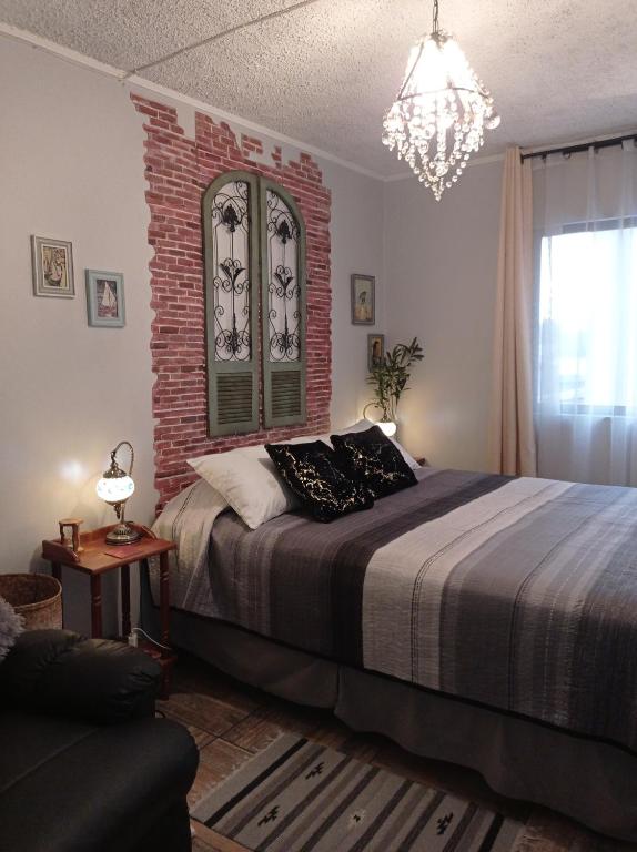 圣地亚哥Dulce hogar的一间卧室设有一张床和砖墙