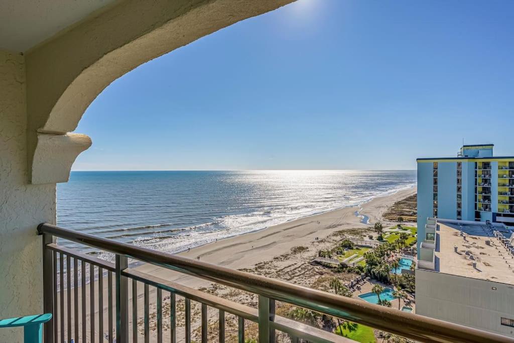 默特尔比奇Caravelle Resort的享有海滩和大楼景致的阳台