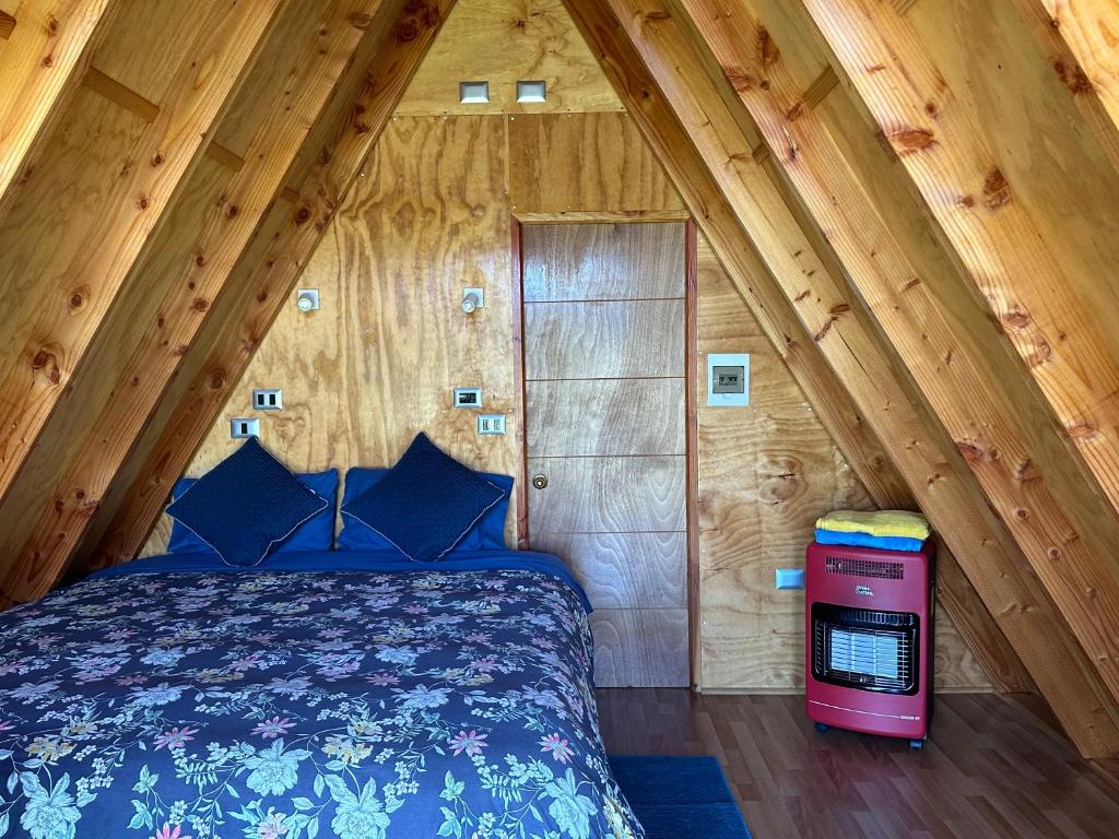 普孔A-FRAME CABIN PUCON的小木屋内一间卧室,配有一张床