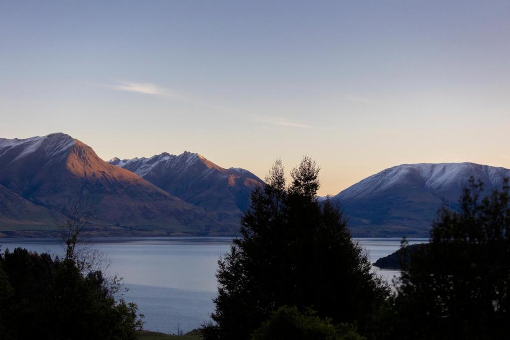 皇后镇Kereru Cottage, Romantic & Beautiful Log Cabin - Queenstown的享有以山脉为背景的湖泊美景