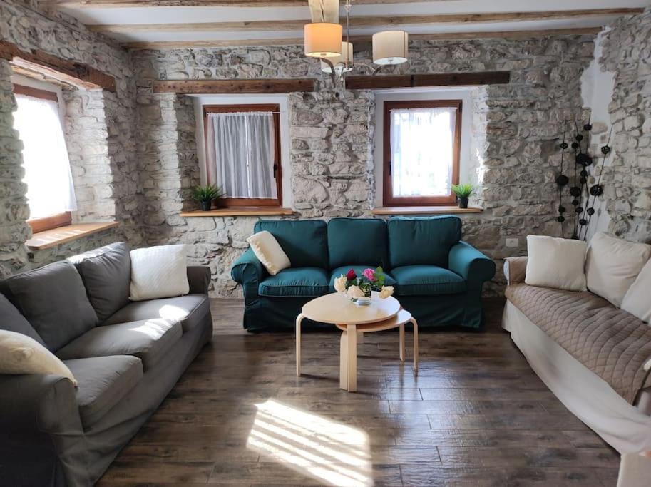 托尔明Casa di Volce - 1801 Stone House的客厅配有蓝色的沙发和桌子