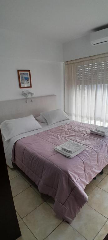 布宜诺斯艾利斯Súper Luminoso en Caballito的一间卧室配有一张大床和紫色毯子