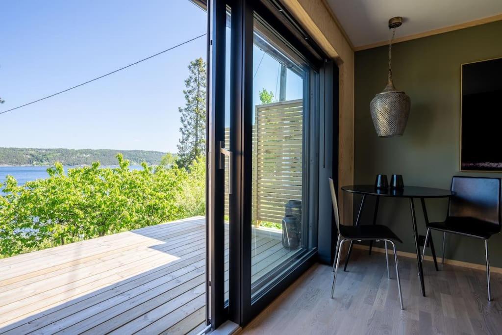 Lekkert gjestehus ved sjøen的客房设有带桌子和玻璃门的阳台。