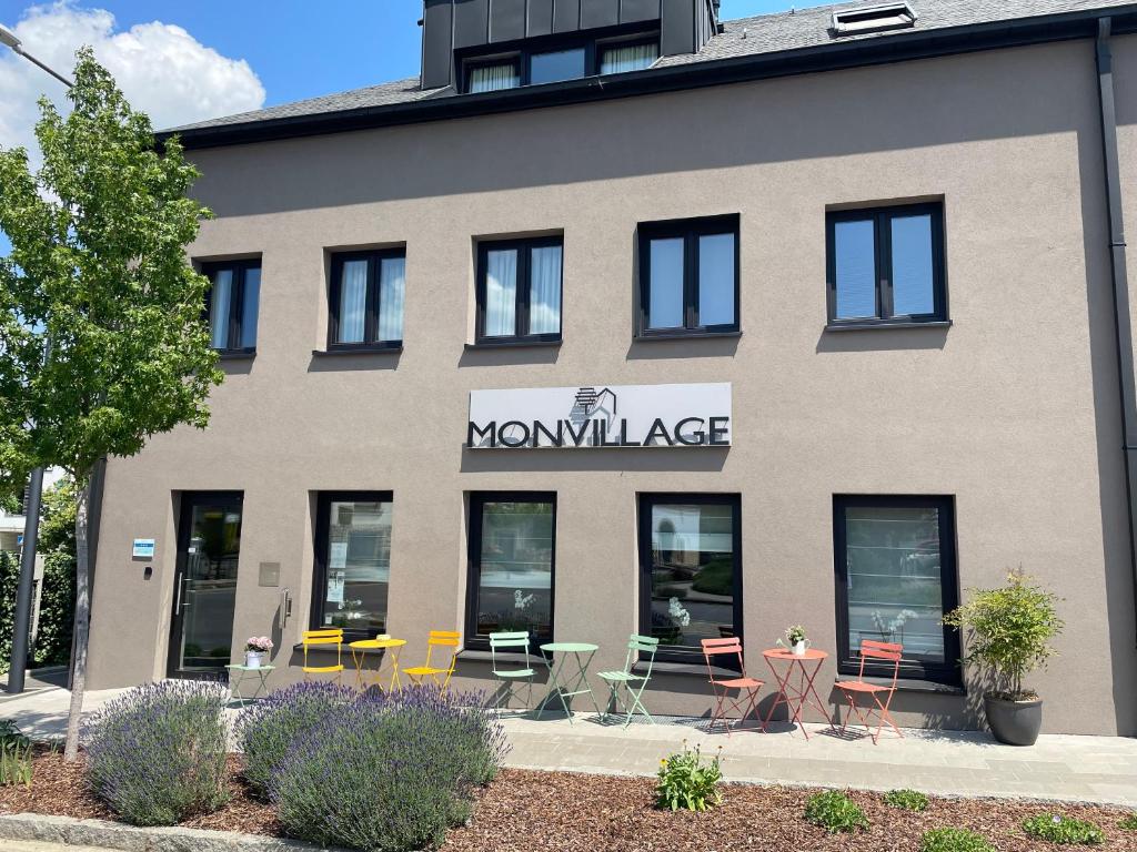 MondercangeHotel Monvillage的前面有桌椅的建筑