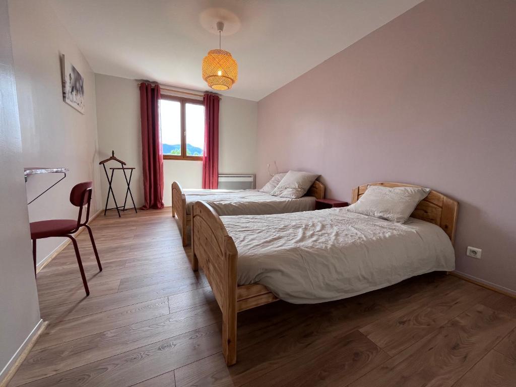 索兹Auberge de Sauze的一间卧室设有两张床、一把椅子和一个窗户。