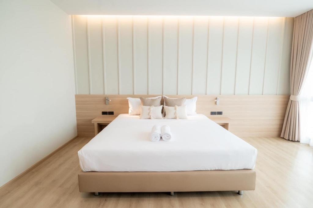 清迈Pillows boutique hotel的卧室配有白色的床和2条毛巾