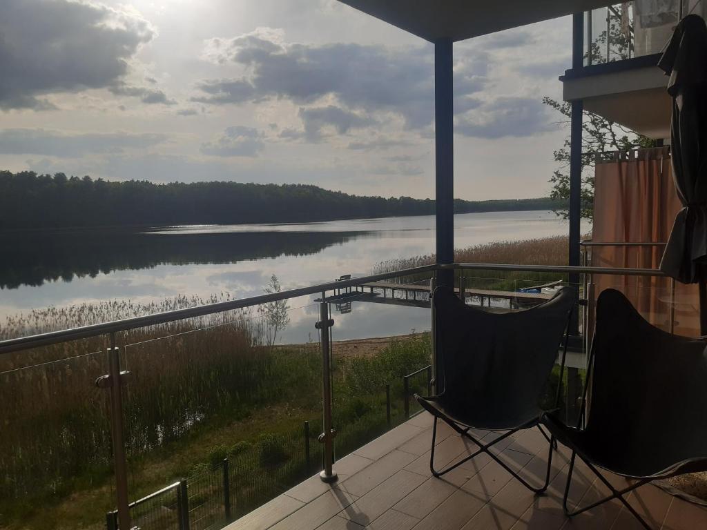 TomaszkowoApartament nr 9 Mazurskie Klimaty的阳台配有两把椅子,享有湖景