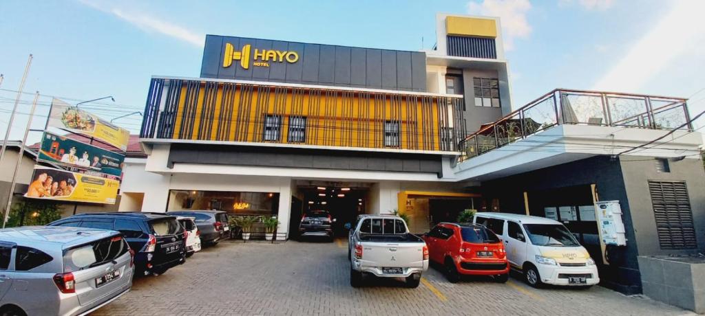 SukaramiHayo Hotel Palembang的停车场,停车场停在大楼前