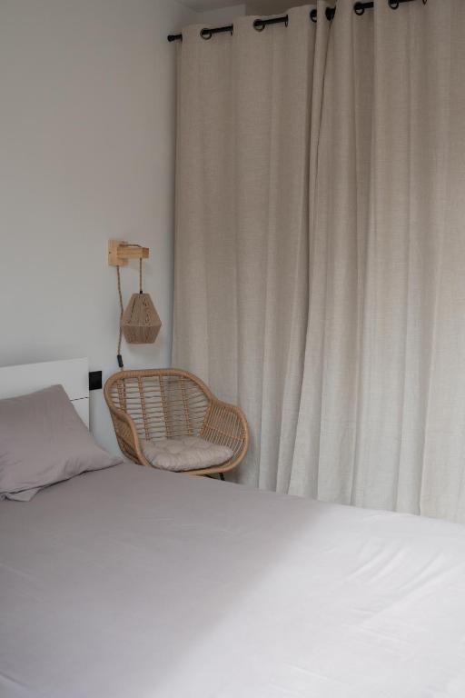 蒙彼利埃Appartement 2 pièces Montpellier centre的卧室配有一张床和一把椅子,靠窗