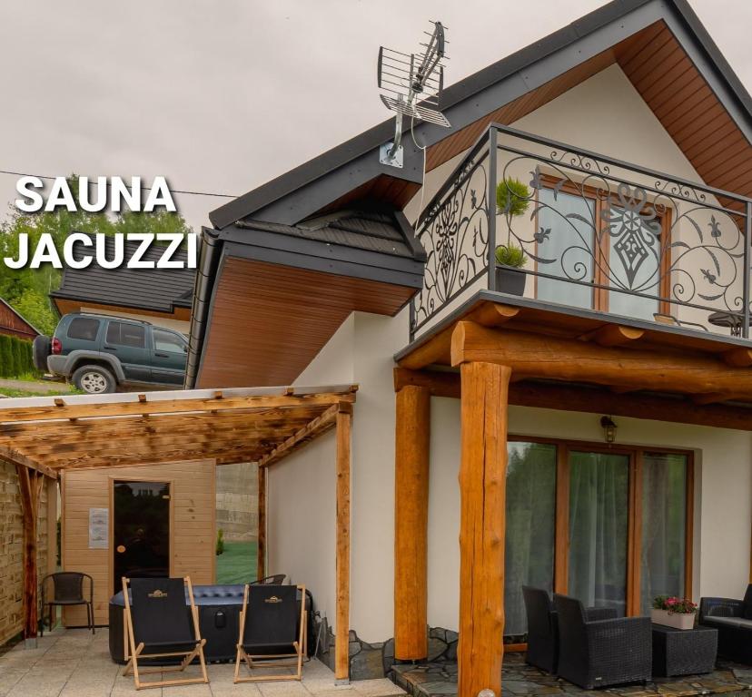新塔尔格Gorczański Resort Domek w Górach Sauna Jacuzzi的带阳台和庭院椅子的房子