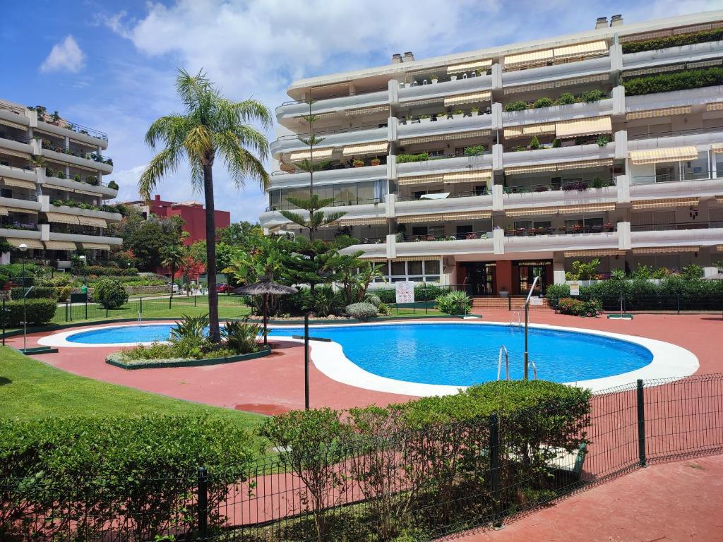 马贝拉Sunny Guadalmina Apartment的公寓大楼前设有游泳池