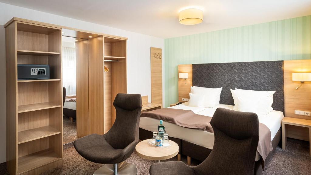 吕德斯海姆环形中央酒店 - 高级的酒店客房,配有一张床和两把椅子