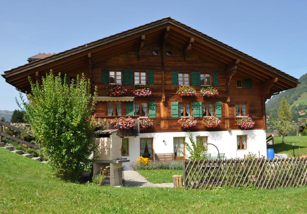 格施塔德Alpenchalet Spiher Gstaad Ferienwohnung im Parterre的一座大型木房子,里面装有花盒