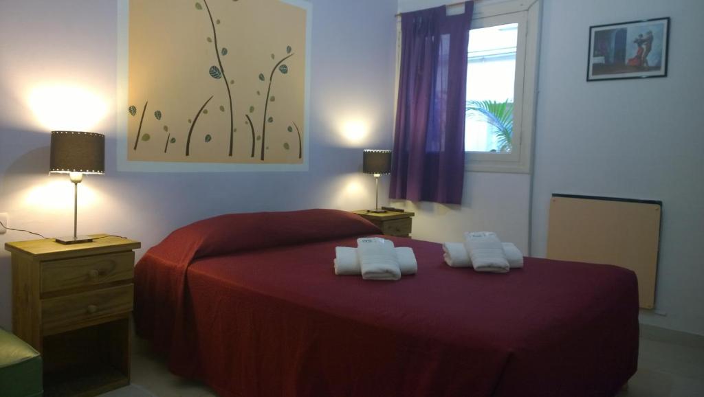布宜诺斯艾利斯克滕酒店的一间卧室配有红色的床和2条毛巾