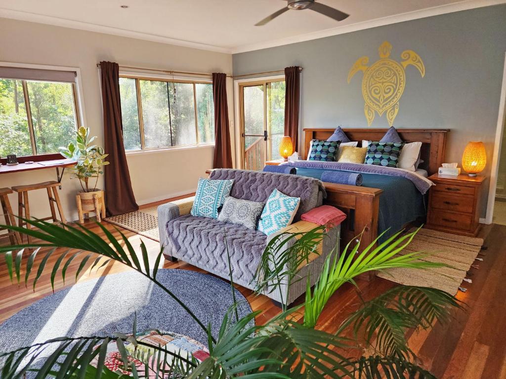 DoonanDeluxe Studio with Forest Views, Noosa Hinterland的一间卧室配有一张床和一张沙发