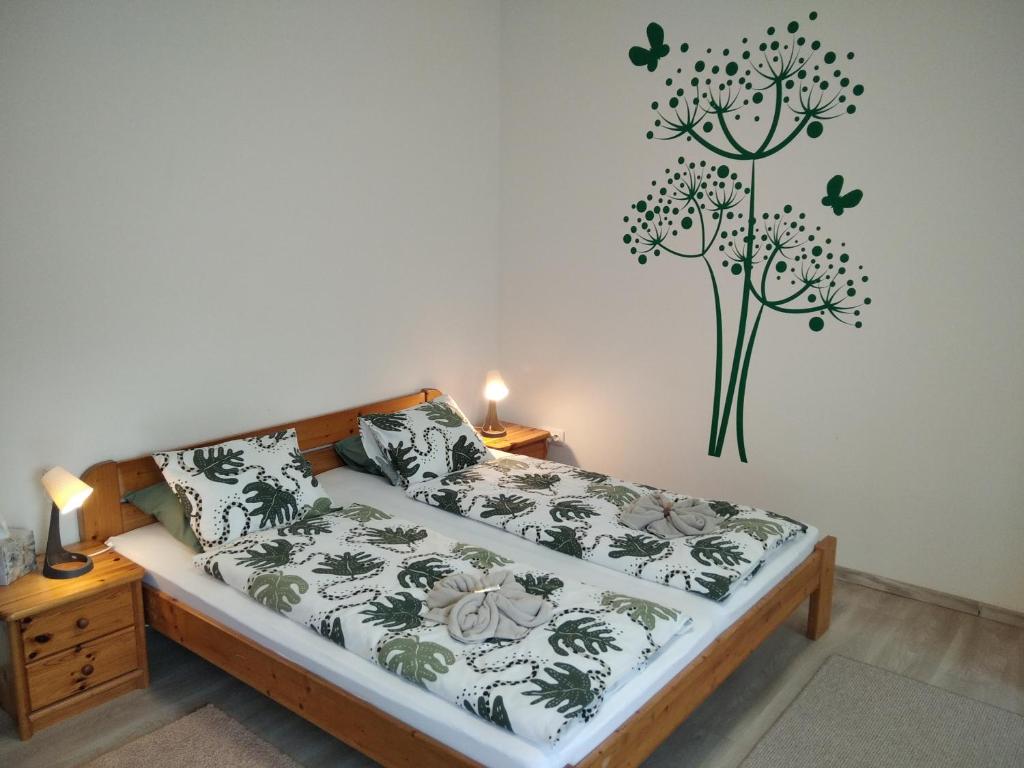 塔塔EszE Vendégszoba的卧室配有一张挂在墙上的植物床