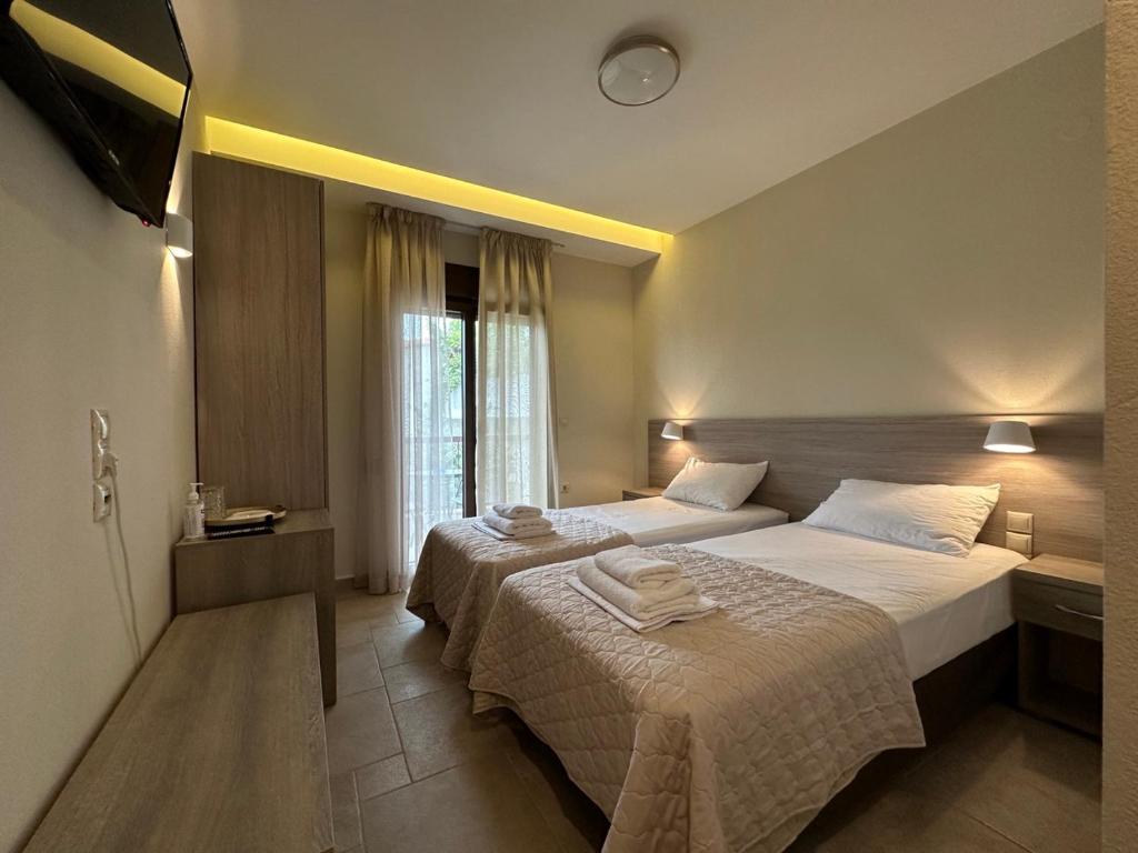 欧拉努波利斯Yulia Luxury Apartment的酒店客房设有两张床和电视。