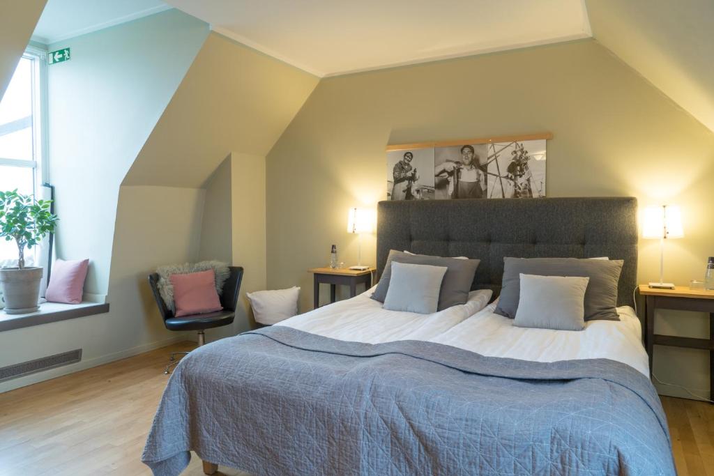 锡姆里斯港Maritim Hotell & Krog的一间卧室设有一张大床和两个窗户。