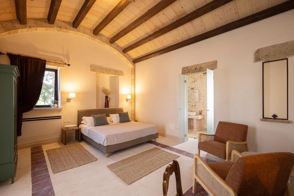 奥斯图尼Masseria San Paolo Grande的一间卧室配有一张床、一张沙发和一把椅子