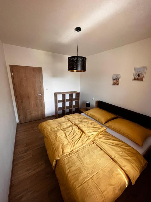 卡什佩尔斯凯霍里Apartmán Kašperák的一间卧室配有一张大床和一个吊灯。