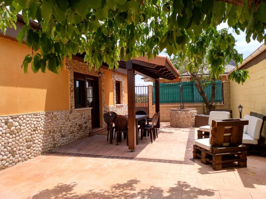 VillalmanzoLa Casita Del Abuelo的一个带桌椅的庭院和一座建筑