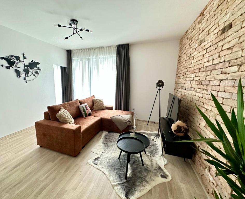 布达佩斯Cityscape Apartment ~ AC/Indoor parking/Balcony的带沙发和砖墙的客厅