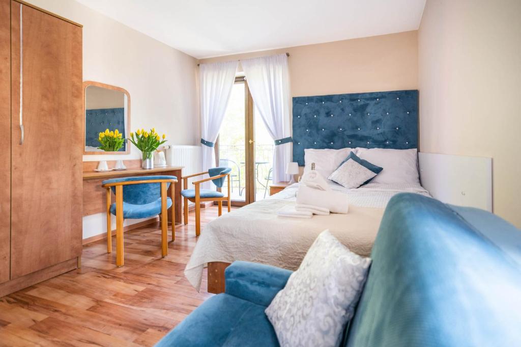 波别罗沃ReveliQa的一间卧室配有一张床和一张蓝色的沙发
