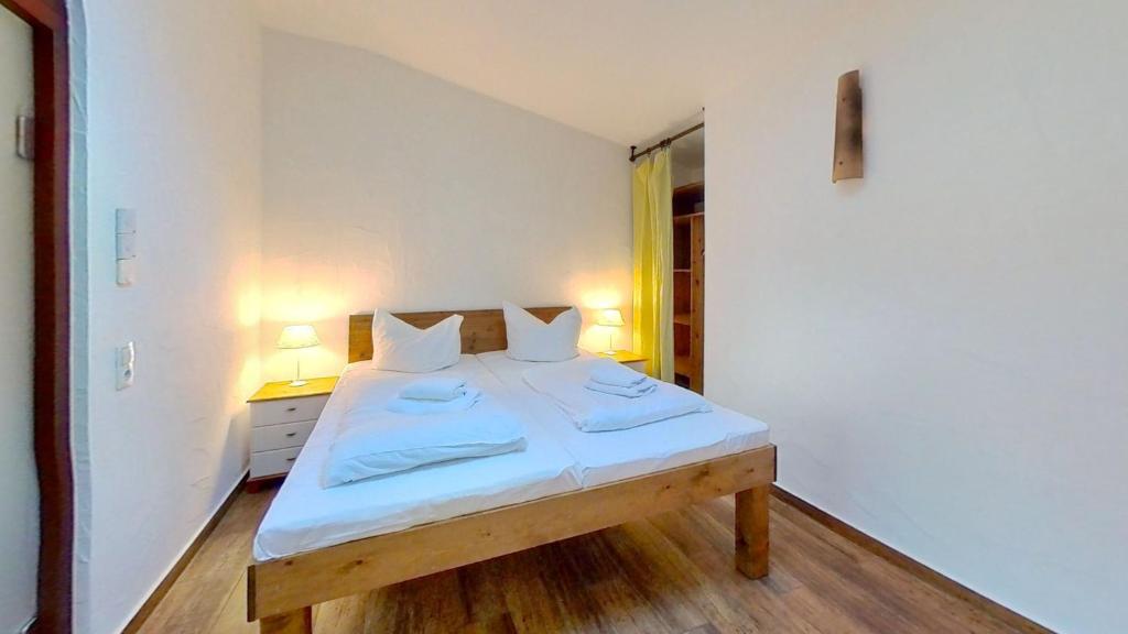 巴贝Las Fincas Baabe的一间卧室配有一张带白色床单和两盏灯的床。