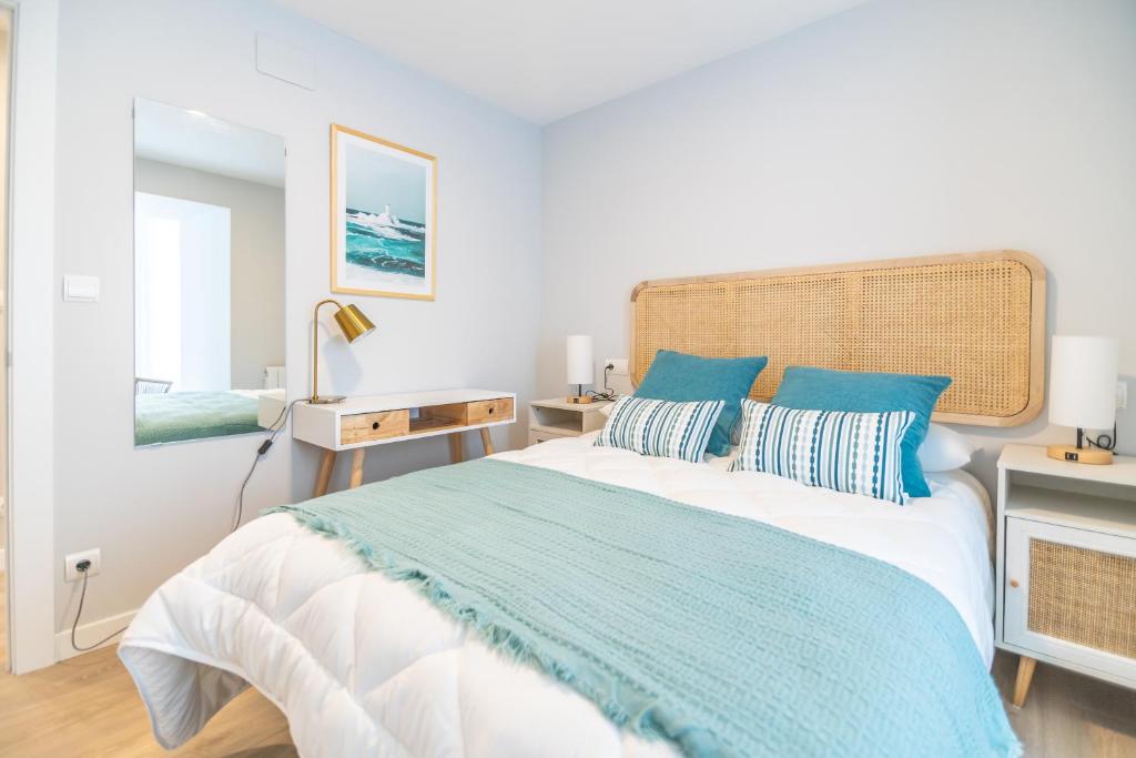 乌迪亚莱斯堡VILLA MARTA - Apartamentos céntricos junto al mar的一间卧室配有一张带蓝色枕头的大床