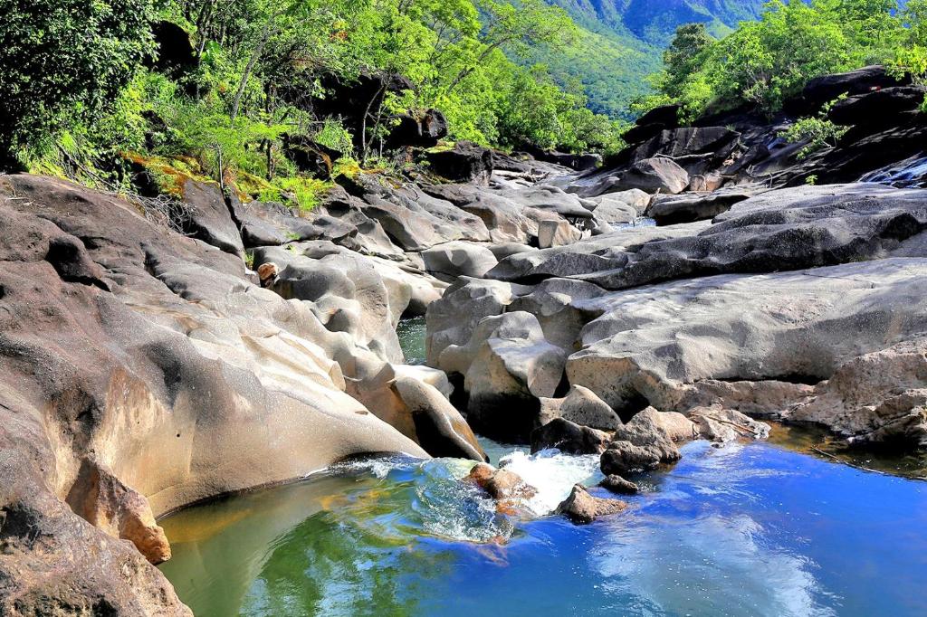 戈亚斯州上帕莱索Chalé tribal的一条有岩石、蓝色水和树木的河流