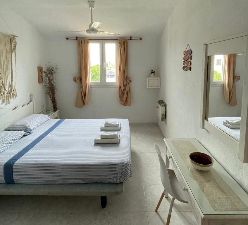卡拉恩弗卡特Atico excelente en Menorca Ciutadella Calan Blanes的一间卧室配有一张床、一张桌子和一面镜子