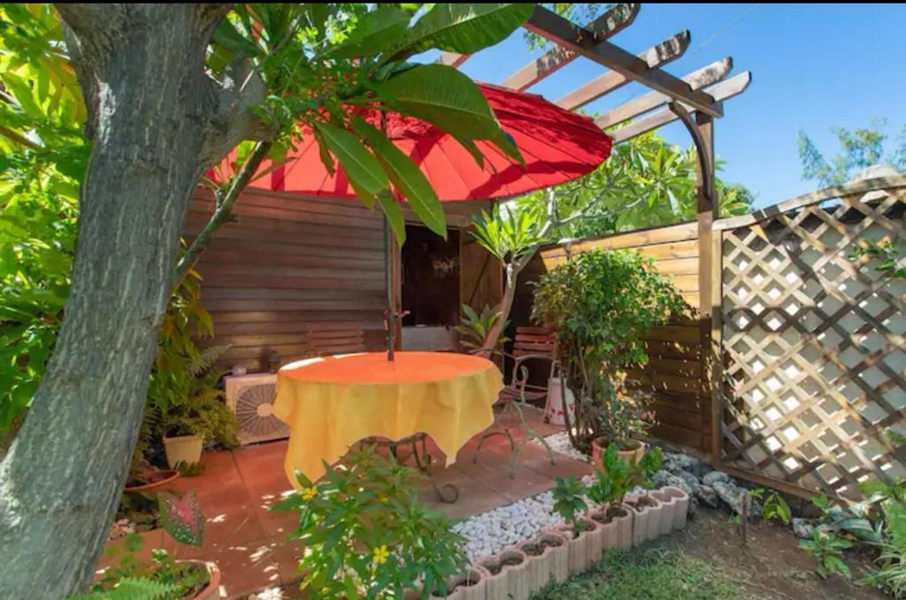 圣勒Leu lagon的一个带桌子和红色遮阳伞的庭院