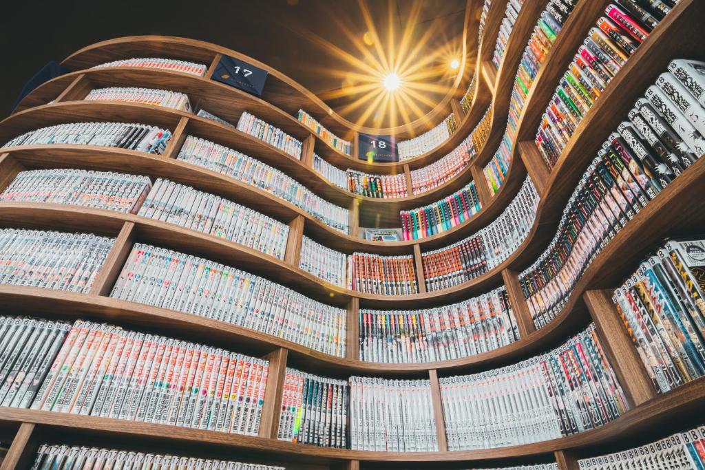 北九州Quintessa Hotel Kokura Comic & Books的天花板上藏有一排书籍的图书馆
