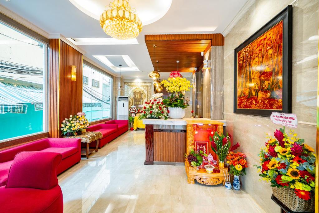 胡志明市Bonka Hotel Luxury Quận 5 HCM的大堂设有粉红色的沙发和商店里的鲜花