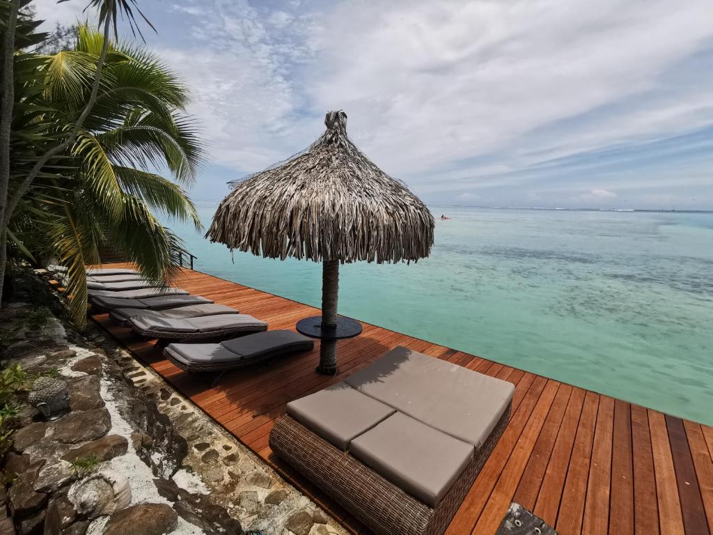 帕佩托艾费努阿马塔伊奥阿酒店的一个带椅子和遮阳伞的甲板和大海