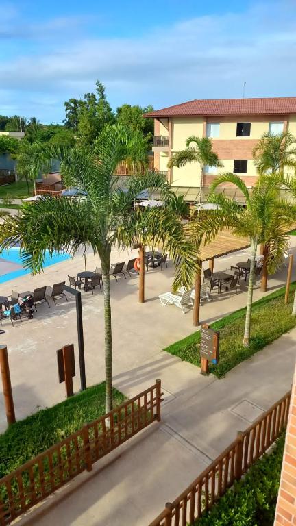 Coroa VermelhaOndas Praia Resort的享有带游泳池和棕榈树的度假村的景致