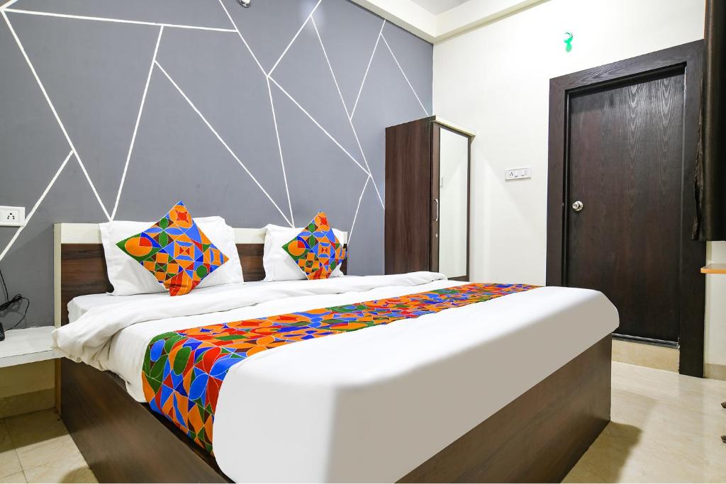 印多尔FabExpress SP7的一间卧室配有一张带色彩缤纷枕头的大床