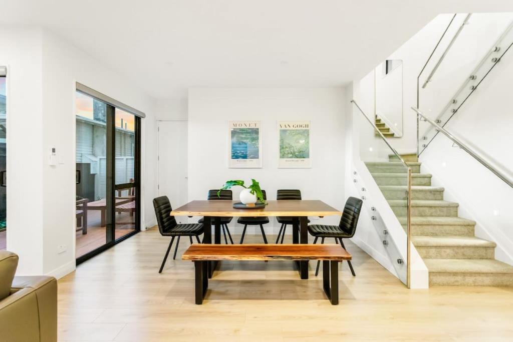 奥克兰Pristine Modern Central Home - Netflix - Heatpump的一间带桌椅和楼梯的用餐室