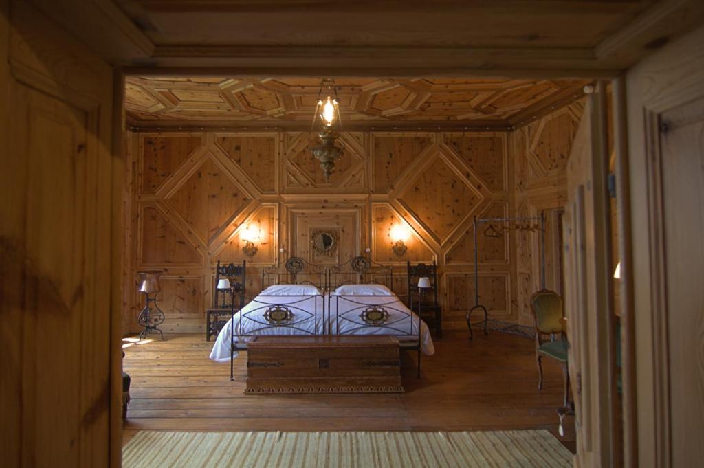 泰廖Palazzo Juvalta的一间卧室设有一张床和木墙